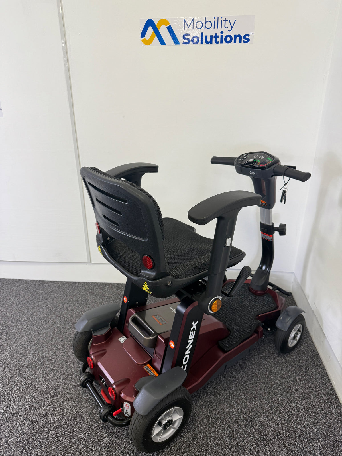 Mobility scooter with 'Mobility Solutions' logo in the background